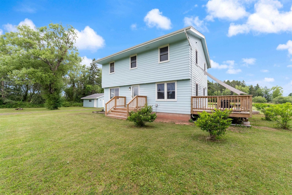 Rear view of house featuring a yard and a wooden deck