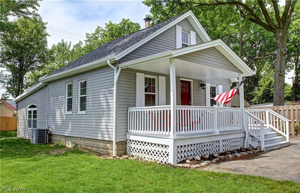 View of front of house with a front yard, central AC unit, and a porch