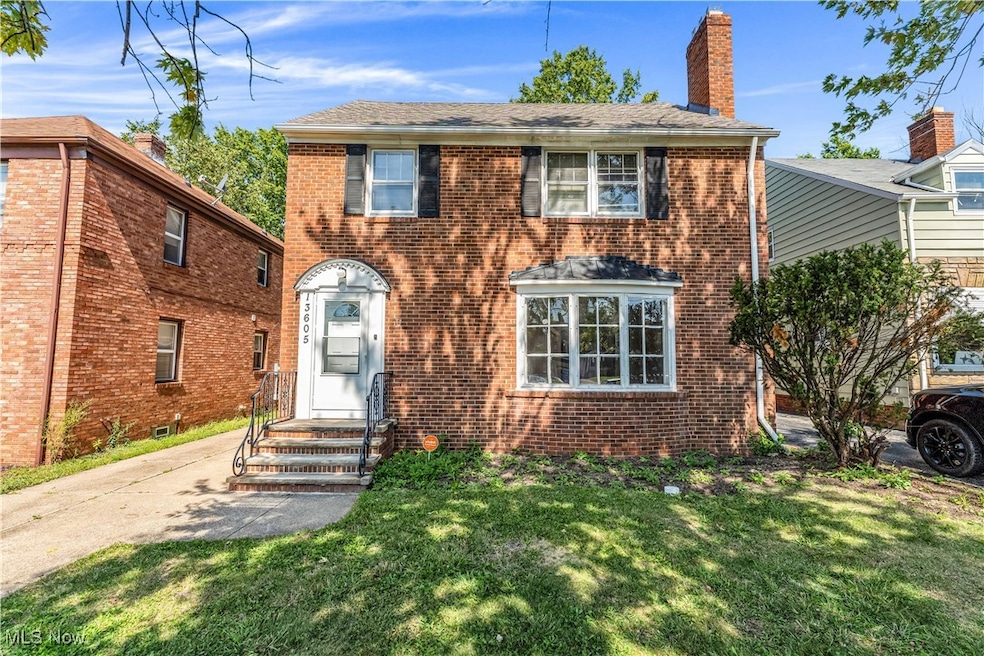 View of front of house featuring brick siding, a front yard, and a chimney