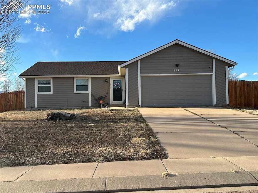 Ranch-style house featuring concrete driveway, fen