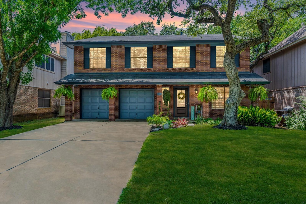 Traditional home featuring brick siding, a front lawn, driveway, and a garage