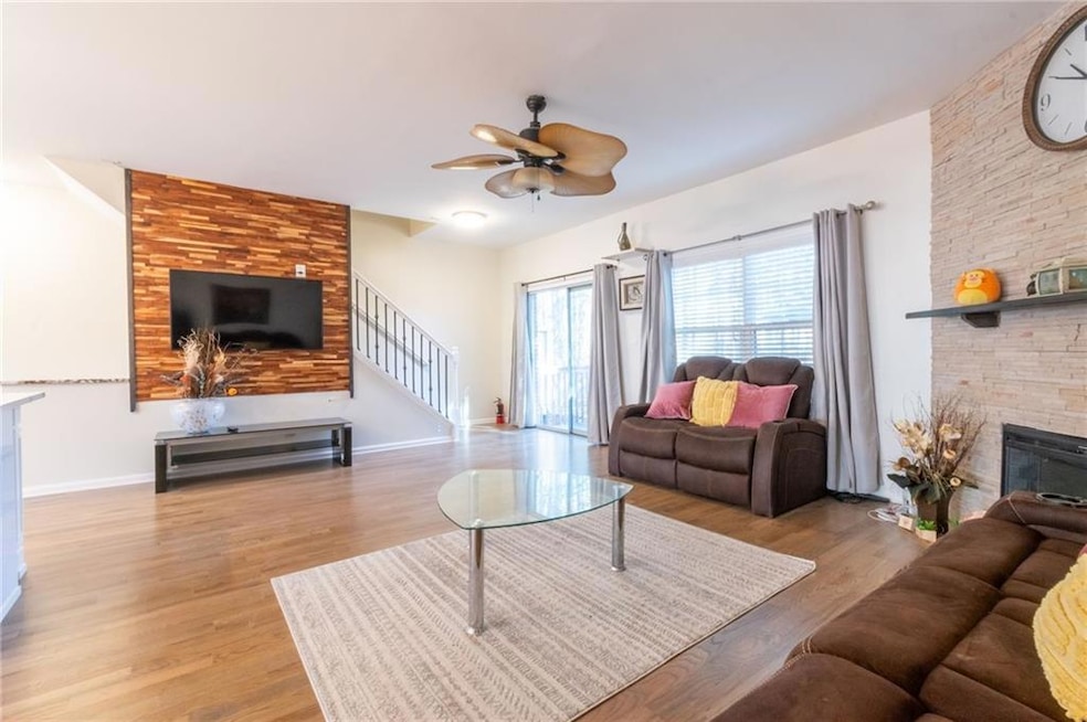 Living room featuring ceiling fan, a fireplace, an