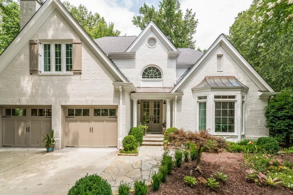 Freshly painted brick home with bay window.