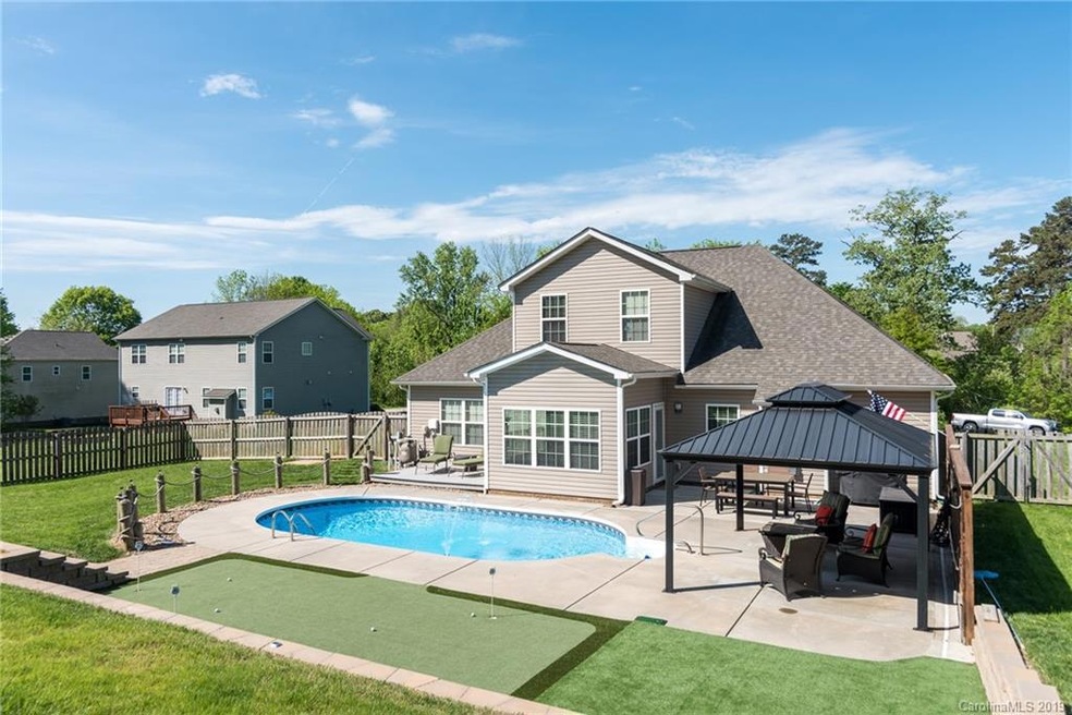 Your oasis awaits! Saltwater pool, putting green, pergola, deck space, fenced in yard with underground pet containment, gas line run for grilling and storage shed. WOW!