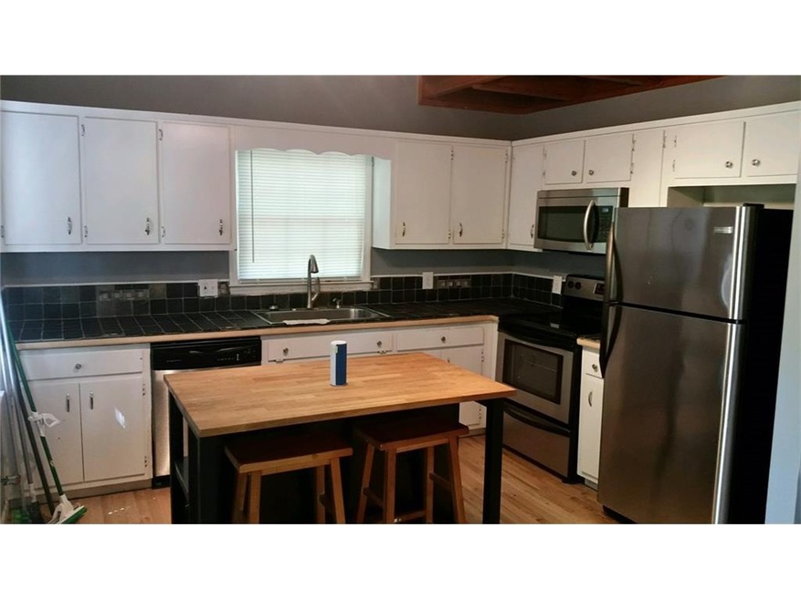 Large kitchen with breakfast area, white cabinets,