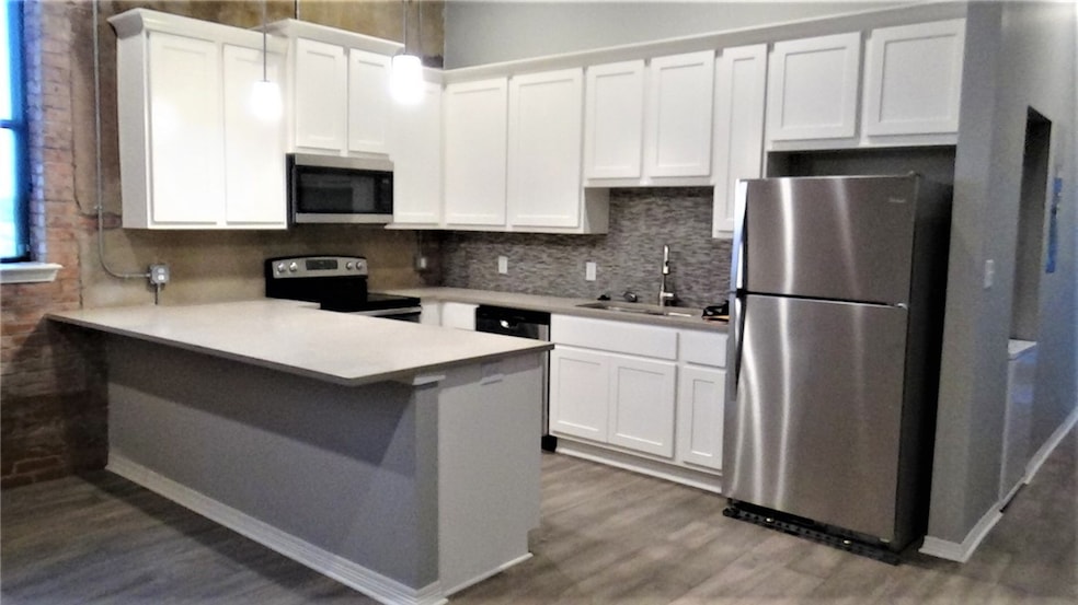 Kitchen featuring white cabinetry, stainless steel