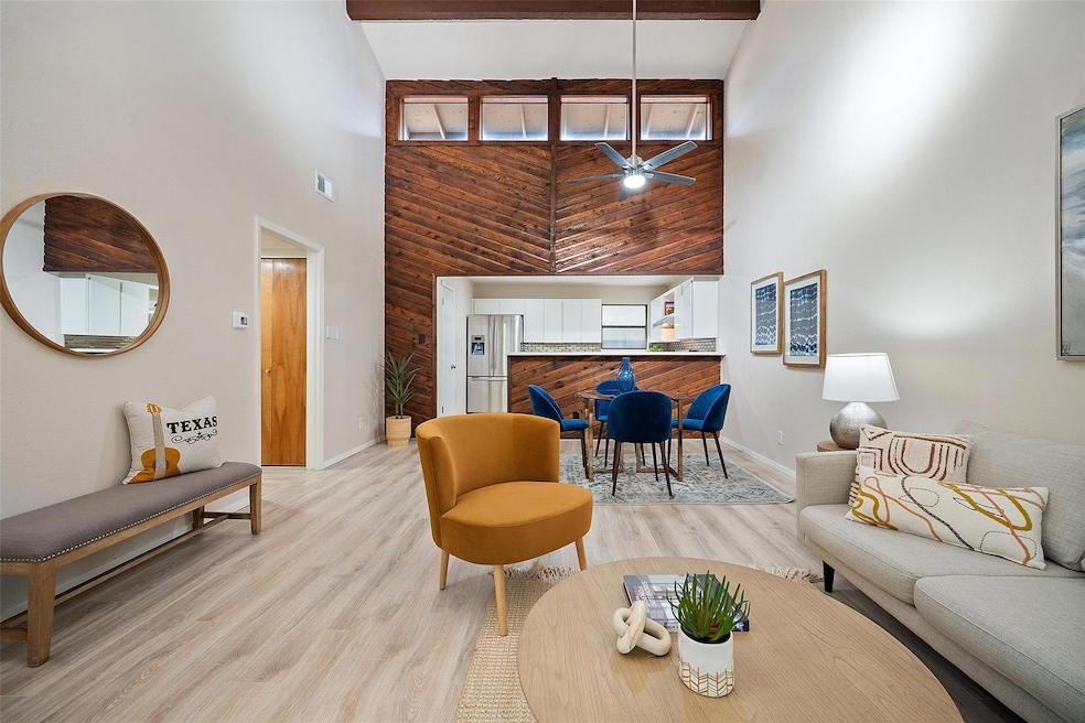 Living room featuring a towering ceiling, baseboa