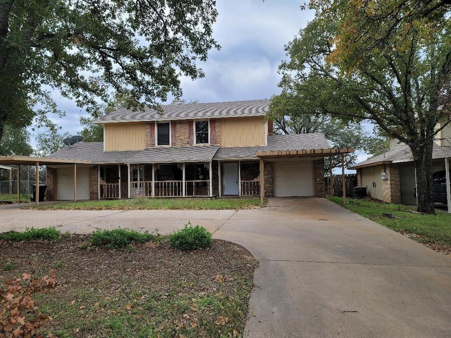 View of front facade featuring a garage, covered p