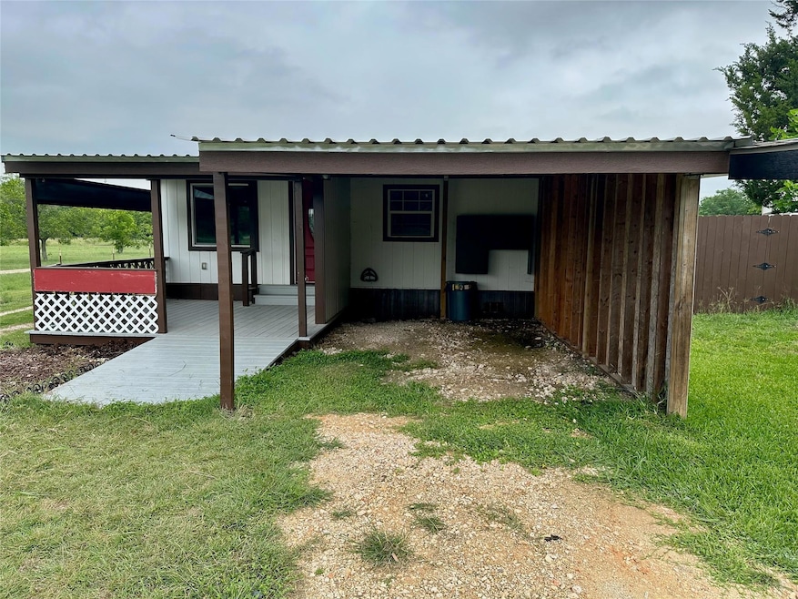 Back of property with a metal roof and a carport