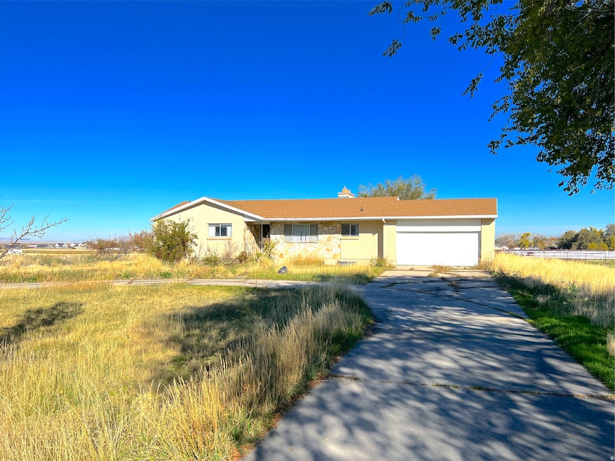 Single story home with driveway, a garage, stucco siding, and a chimney
