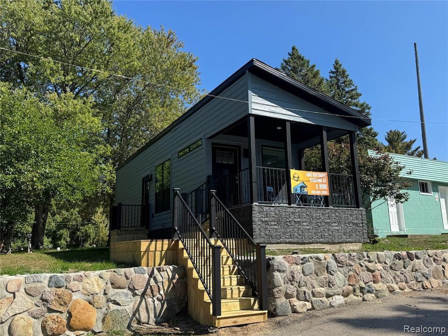 Shotgun-style home featuring covered porch and stairway