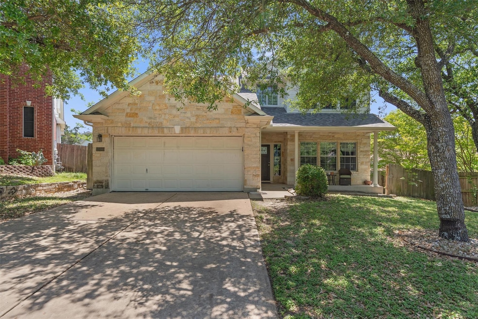 Traditional home with driveway, stone siding, fen