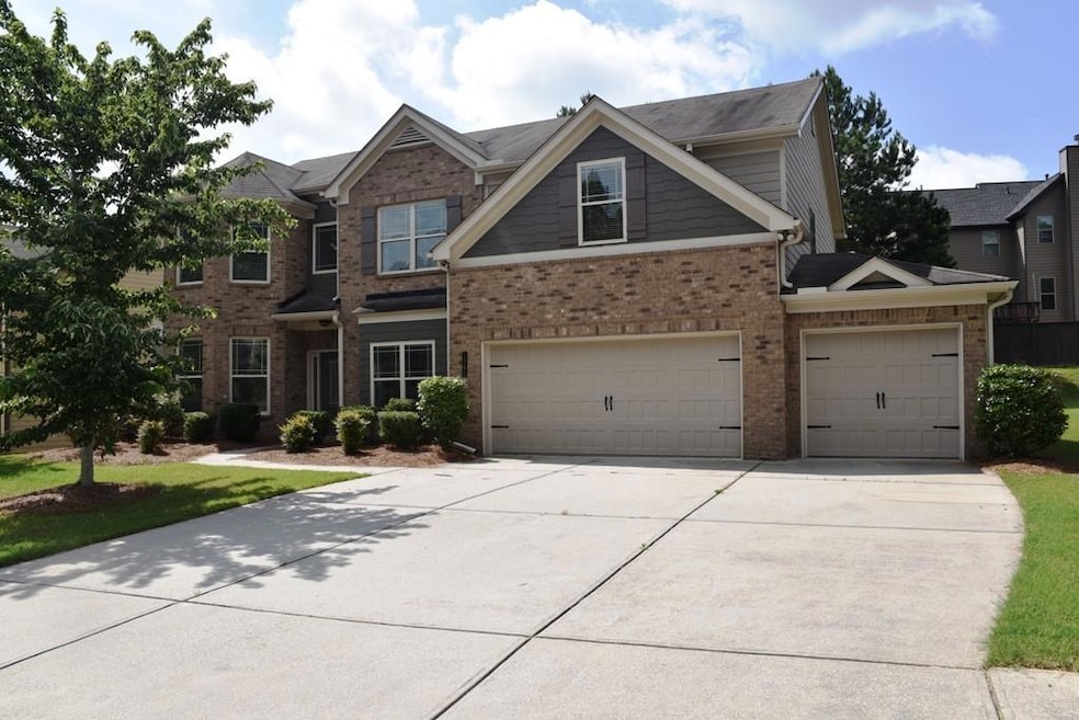View of front of home featuring brick siding, concrete driveway, and a garage