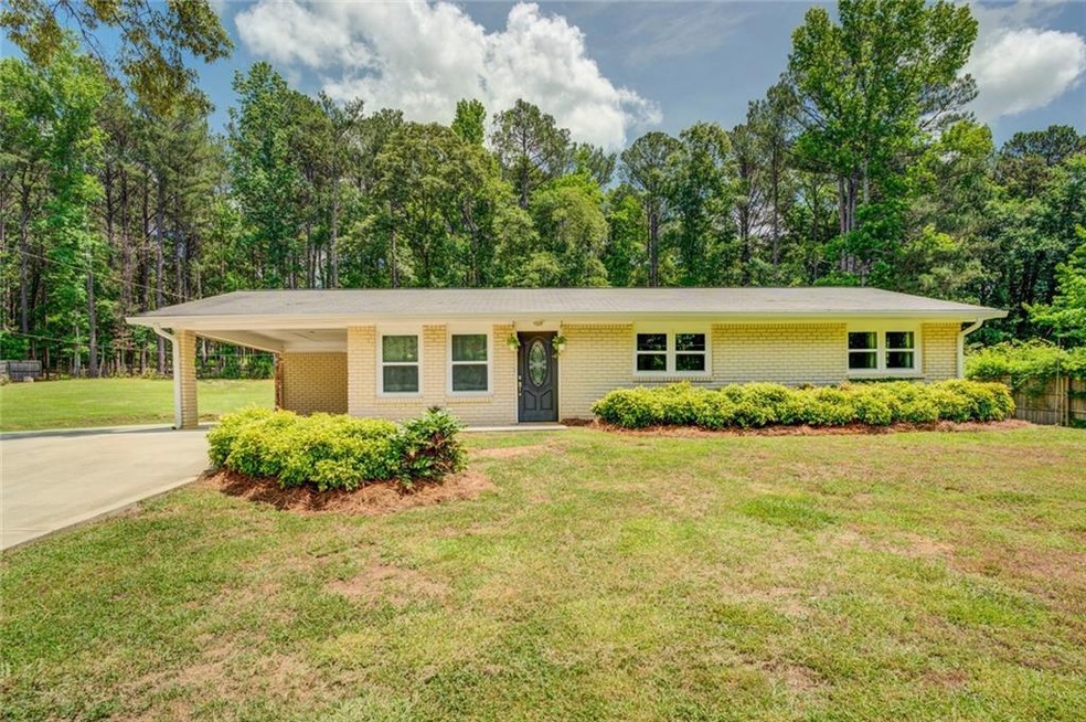 Single story home with a front yard and a carport