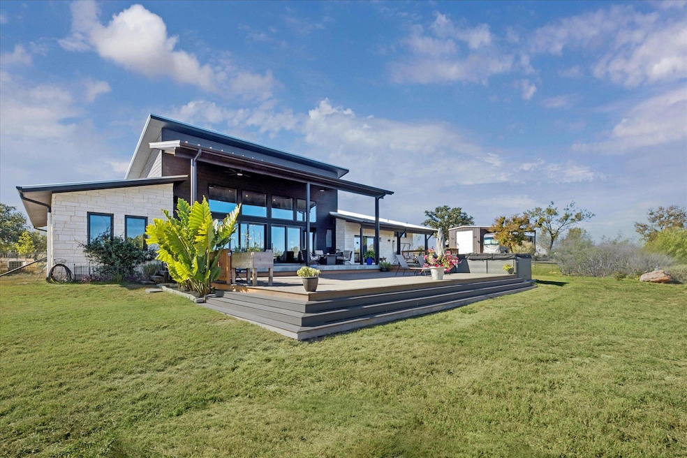 Back of house with a lawn and a patio
