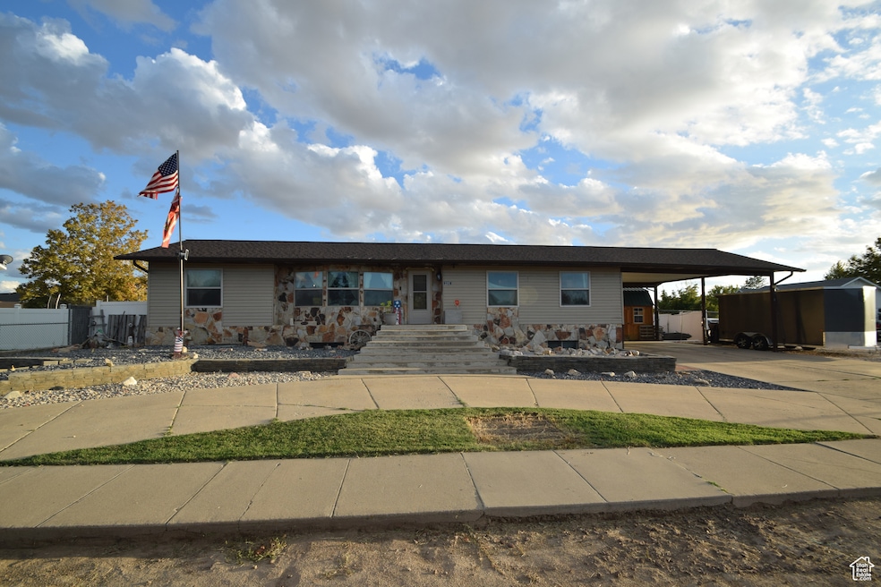 View of front of property featuring a carport and driveway