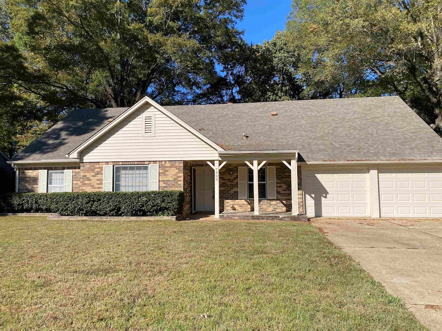 Ranch-style home featuring covered porch, a front yard, brick siding, and driveway