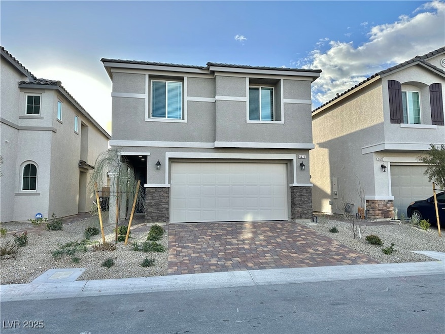 View of front facade with a garage, stone siding,