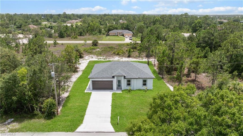 Aerial view of property and surrounding area featuring a forest