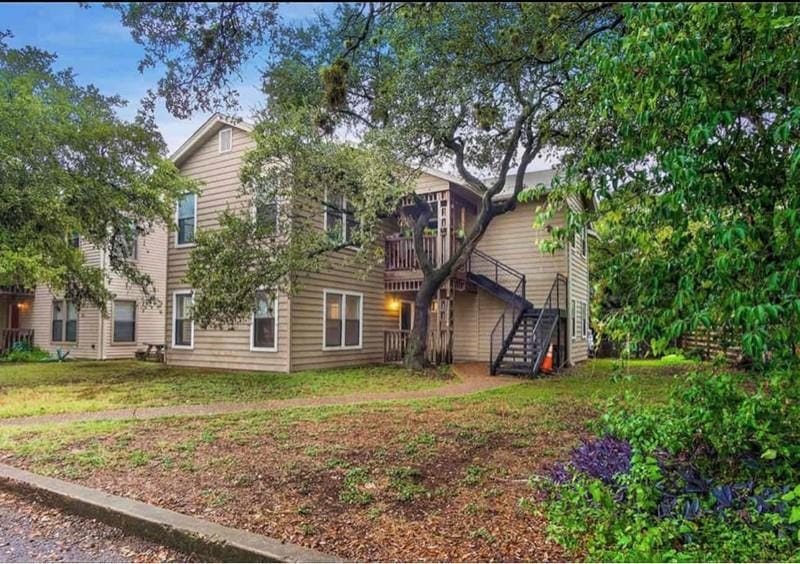 Back of property featuring a yard and stairs