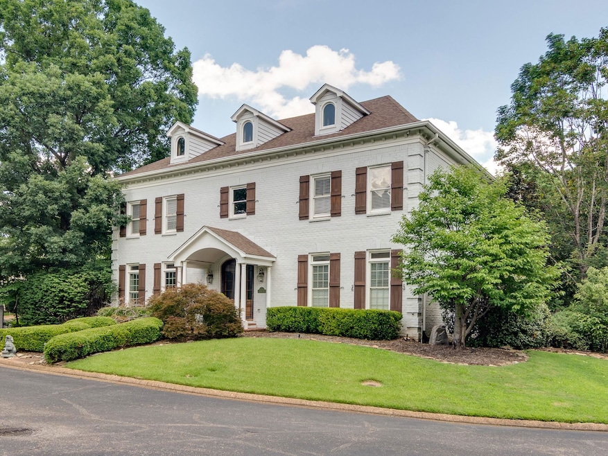 Colonial-style house featuring brick siding and a front lawn