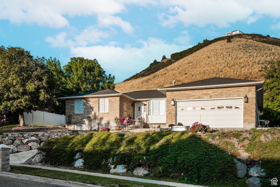 Ranch-style house with brick siding, a mountain view, and an attached garage