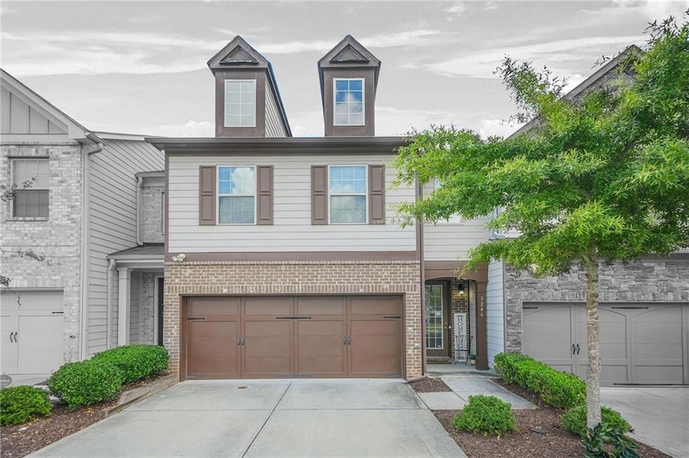 Multi unit property with driveway, brick siding, and an attached garage