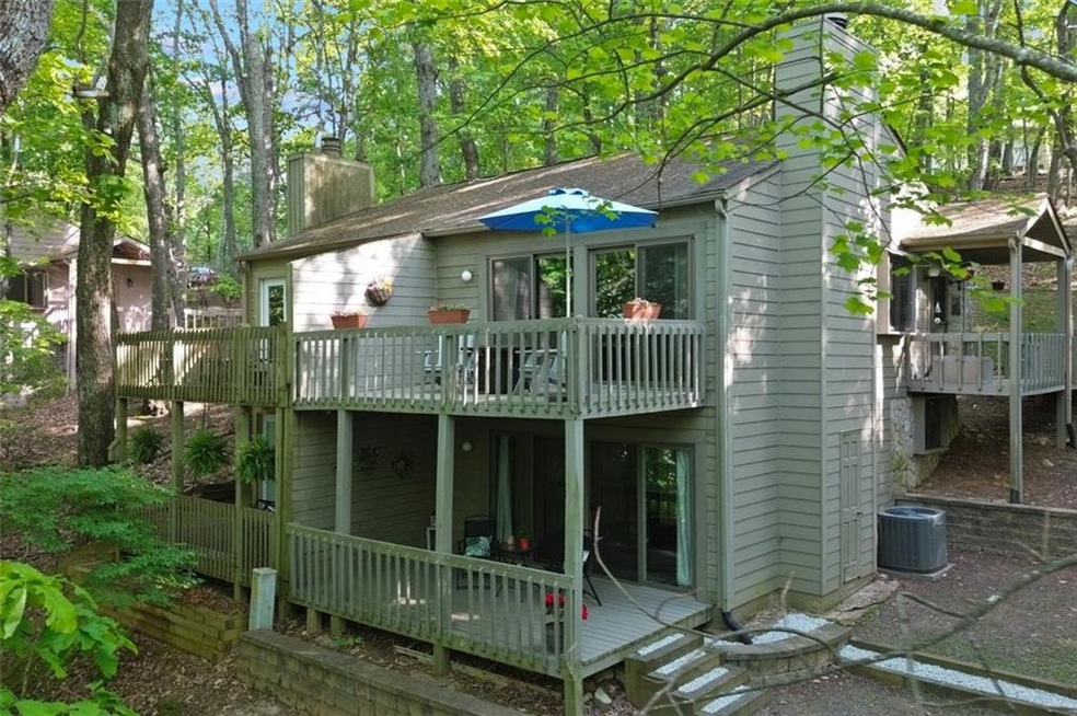 Back of property with a deck, central AC, a chimney, and a balcony