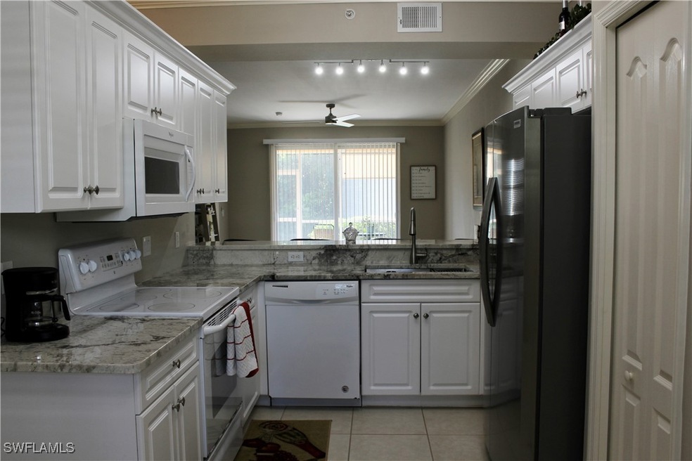 Kitchen with sink, white cabinetry, white applianc