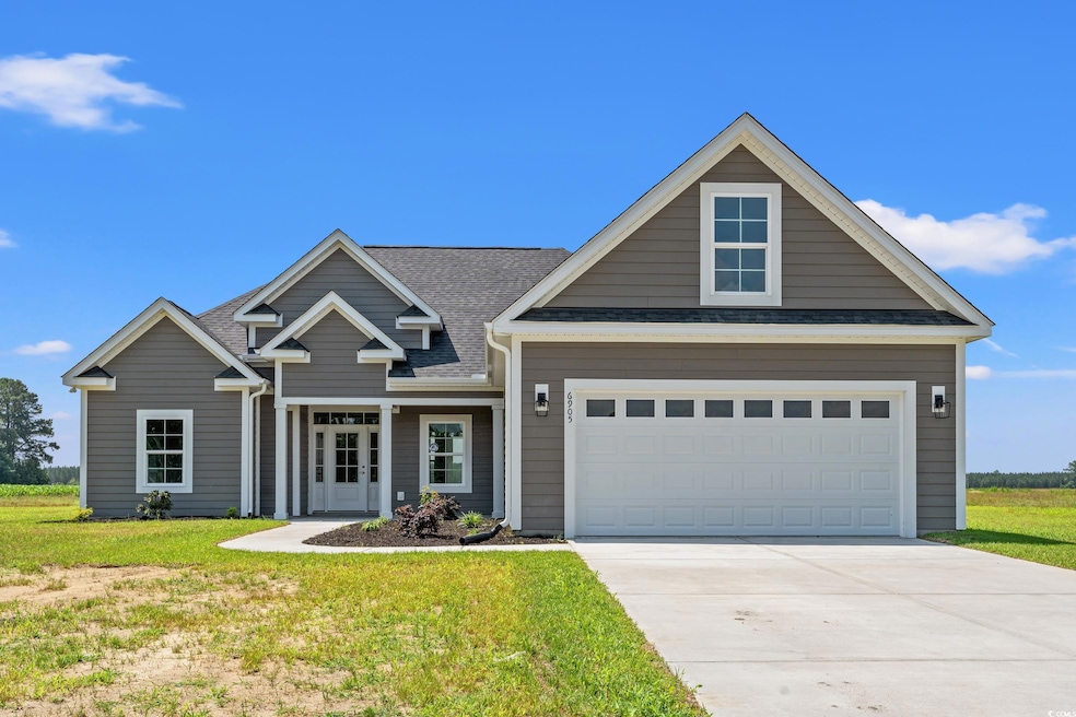 View of front facade with driveway, a front lawn, and roof with shingles