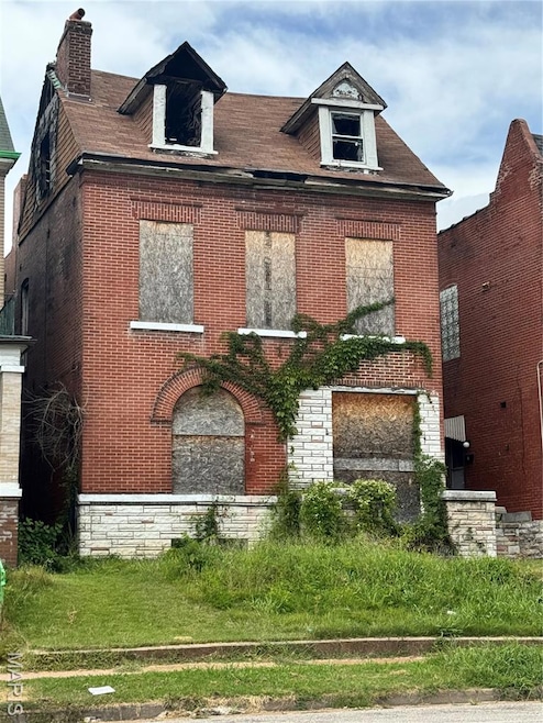 View of front of property with brick siding, a chimney, and stone siding