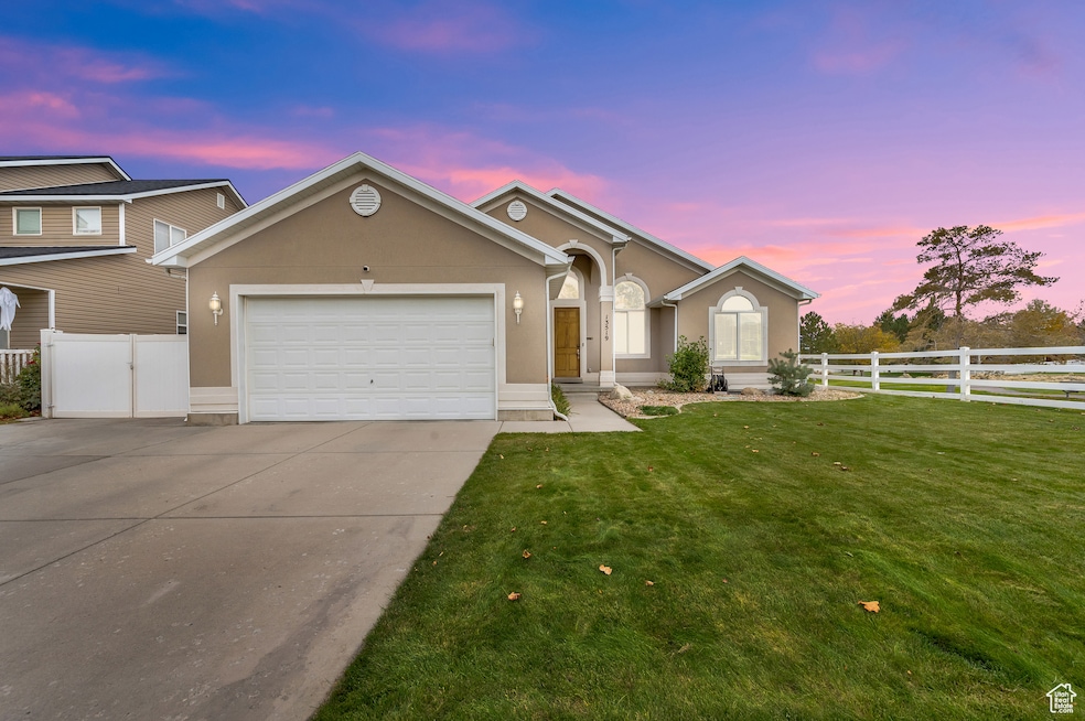 Single story home featuring stucco siding, driveway, and an attached garage