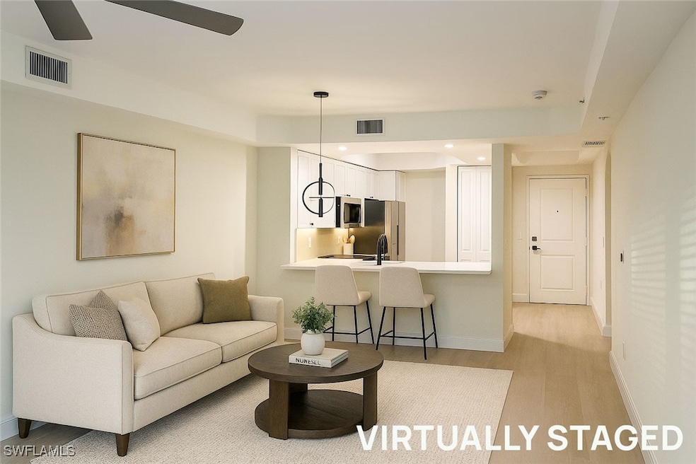 Living room with light wood-type flooring and recessed lighting
