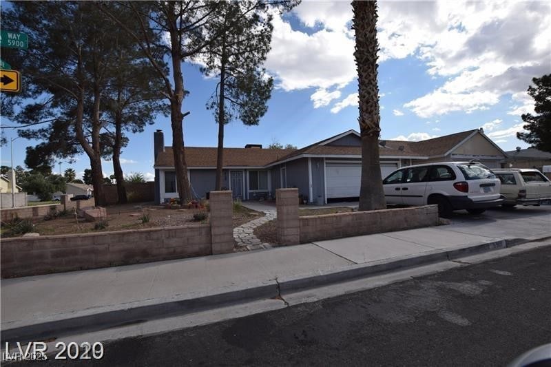 Single story home featuring driveway, a chimney, a