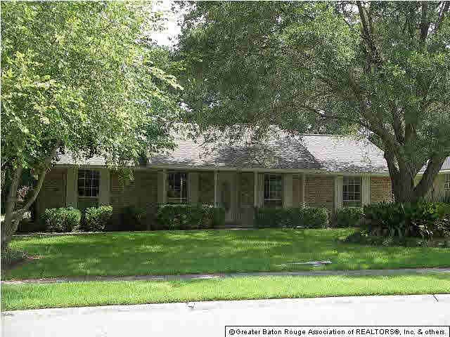 Front of home with mature landscaping.