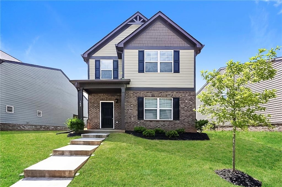 Craftsman-style home with brick siding and a front lawn