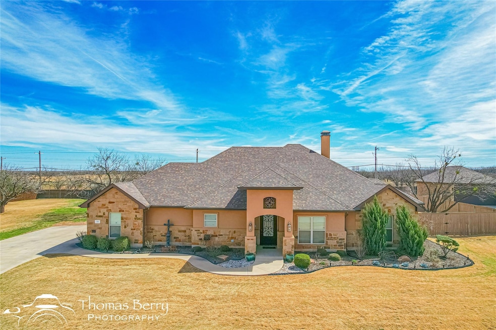 View of front facade with a front yard, fence, sto