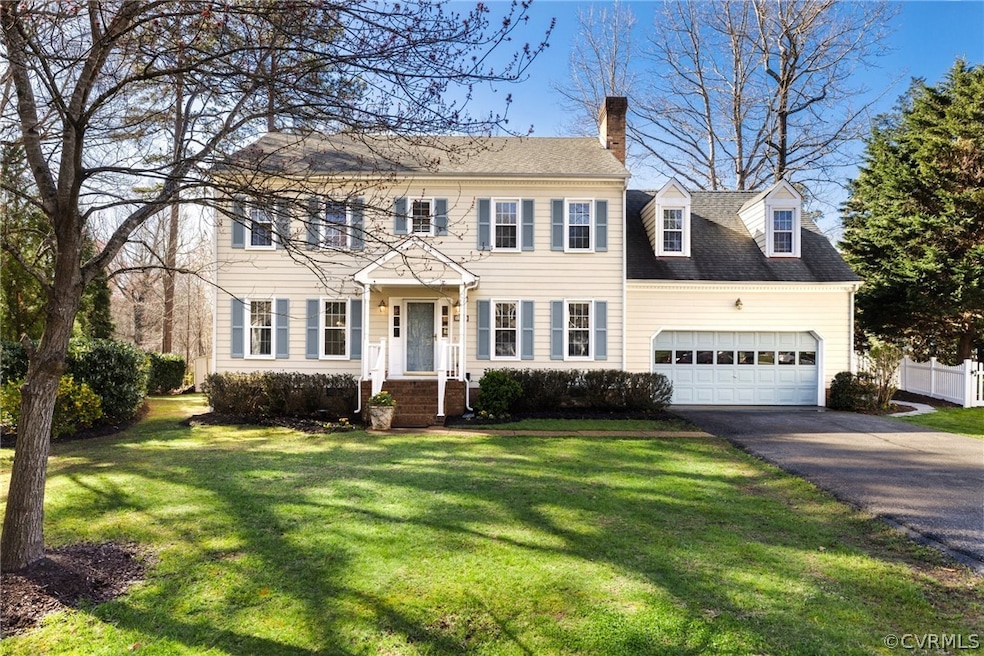 Colonial home featuring a garage and a front yard