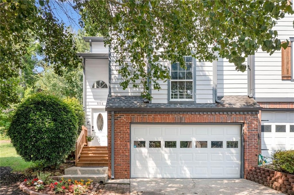 View of front of property with brick siding, an attached garage, and concrete driveway