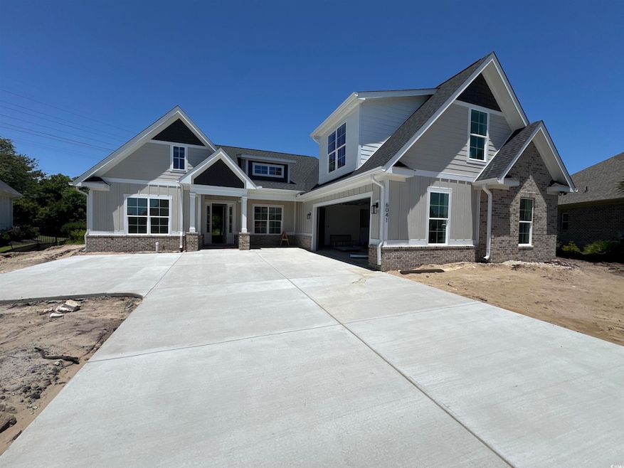 Craftsman house with concrete driveway, a garage, and brick siding