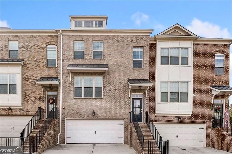 Multi unit property featuring brick siding, an attached garage, and driveway