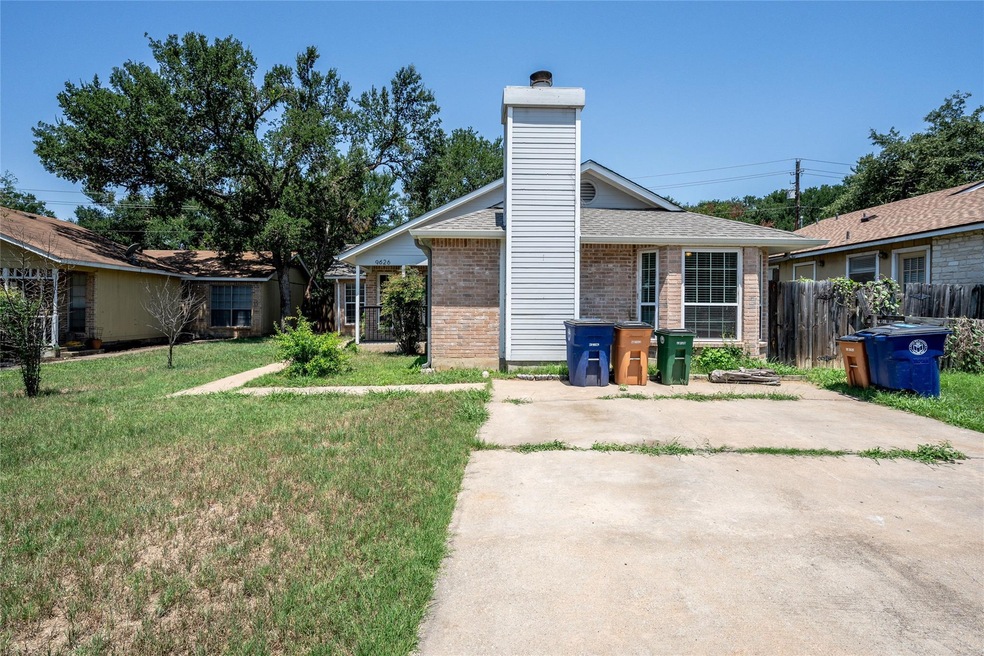 Back of property featuring a chimney, fence, bric