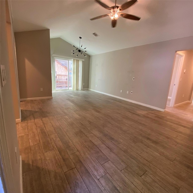 Spare room featuring vaulted ceiling, wood finish