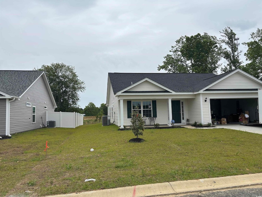 Ranch-style home with a garage, central air condition unit, driveway, and covered porch