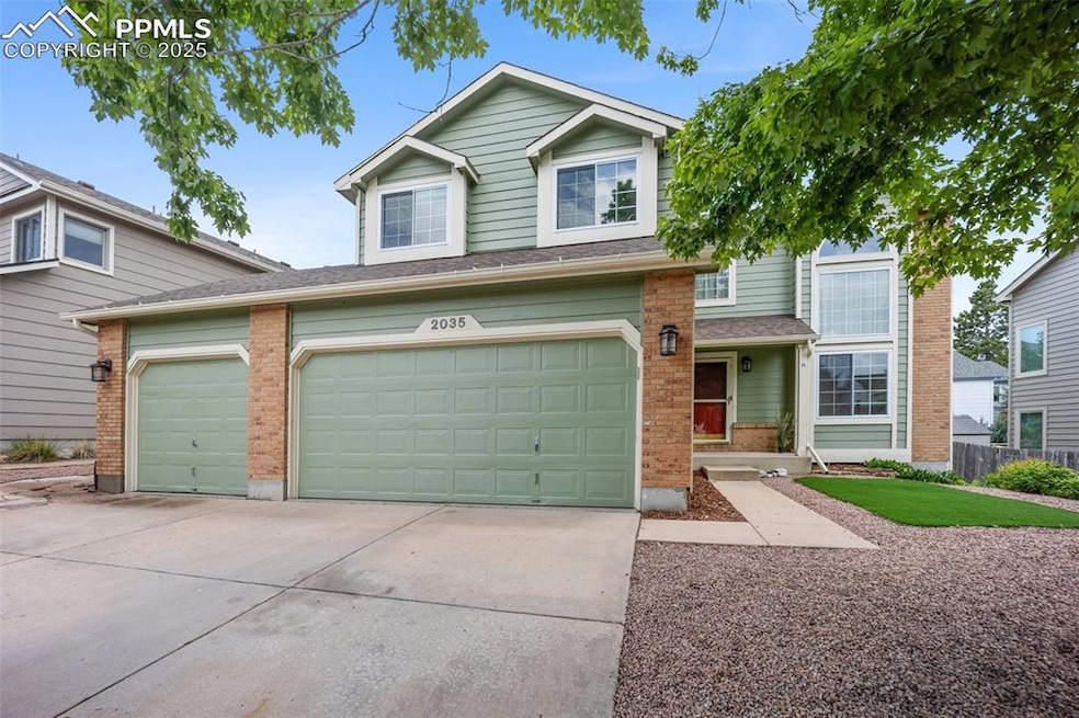 View of front of home with driveway, brick siding, and a garage