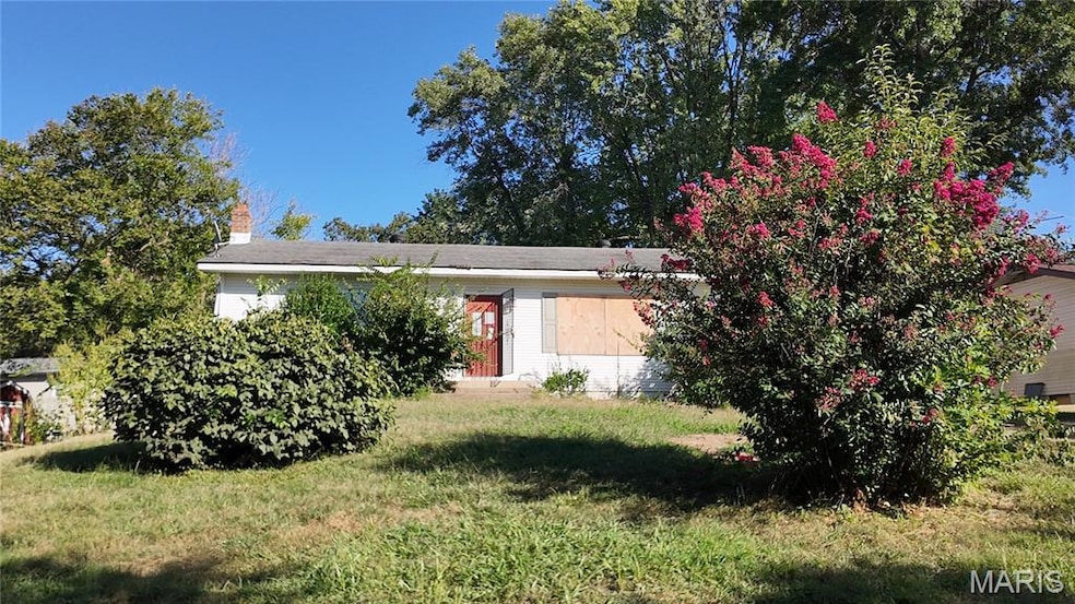View of front facade featuring a front lawn and a chimney