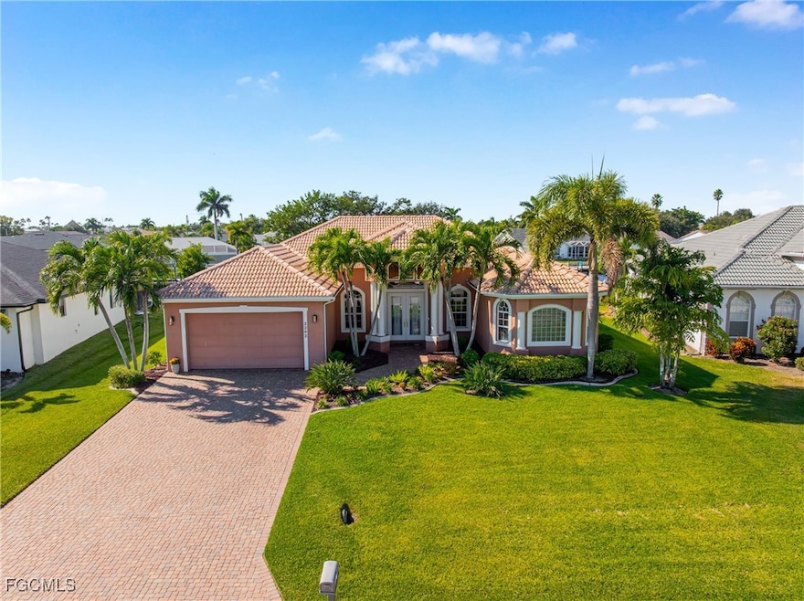 Front view of home featuring stucco siding, a tiled roof, decorative driveway, and a front lawn