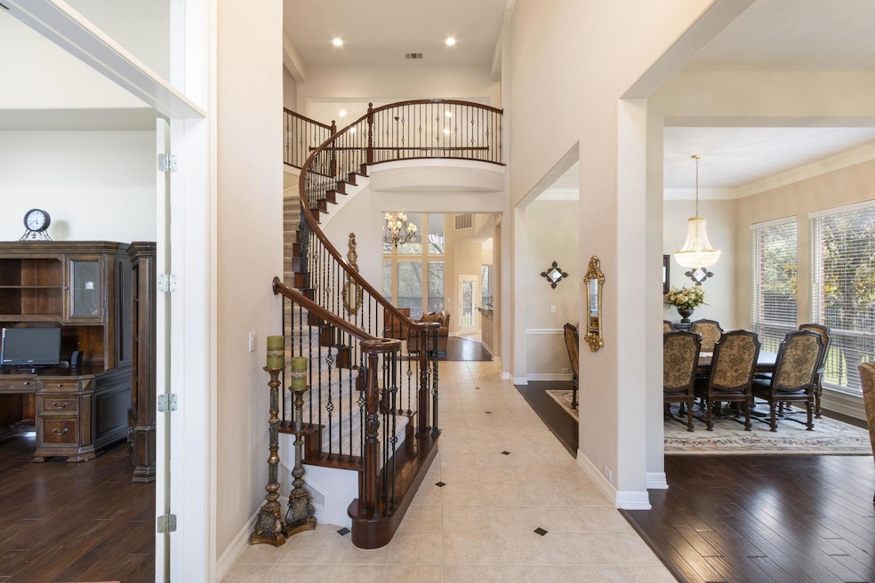 Entryway featuring stairs, baseboards, a high ceiling, wood finished floors, and recessed lighting