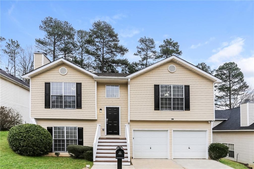 Raised ranch featuring an attached garage and conc