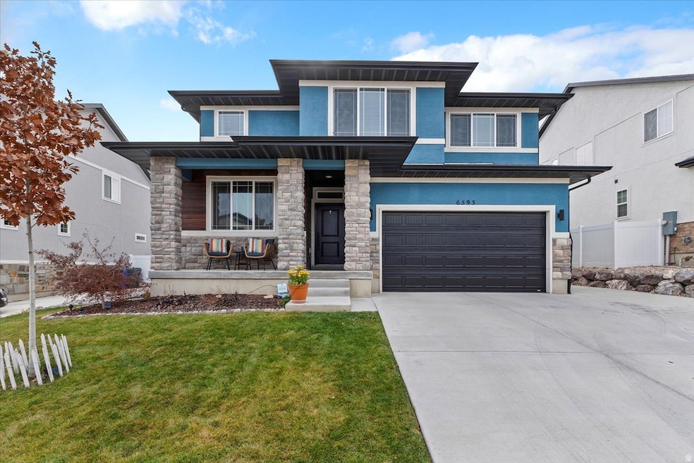 Prairie-style home featuring stucco siding, stone siding, a porch, and an attached garage